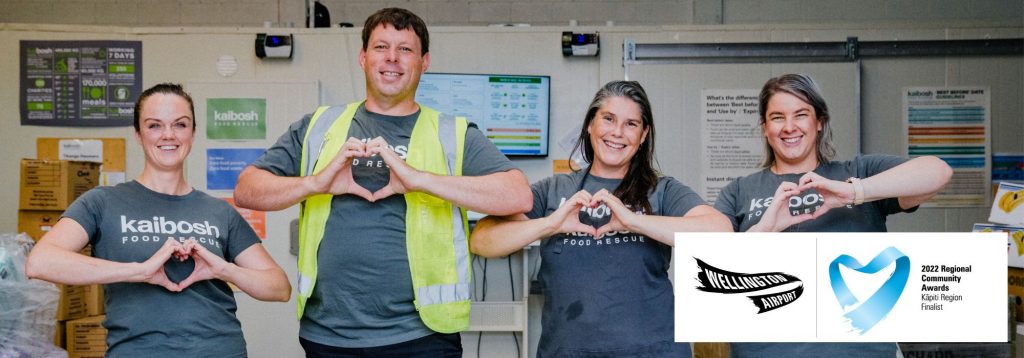 Four Kaibosh staff stand with hands as hearts, with icon overlaying photo: Finalist in Wellington Regional Community Awards, Kāpiti.