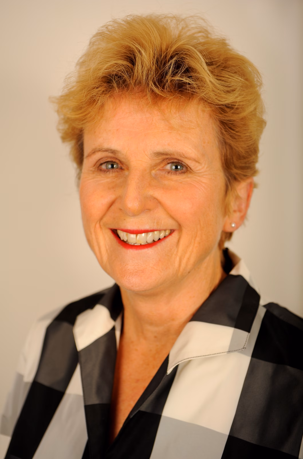 Woman with short hair wearing black and white shirt. Dame Diana Crossan.